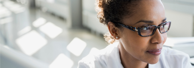 Rosemont Pharmaceuticals - Lady in lab coat with glasses smiling